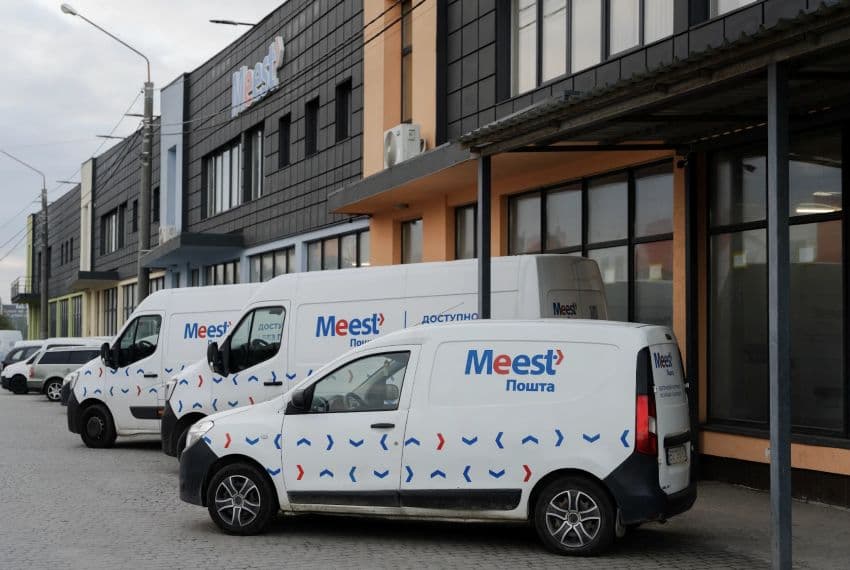 Автомобілі компанії Meest ПОШТА припарковані біля будівлі