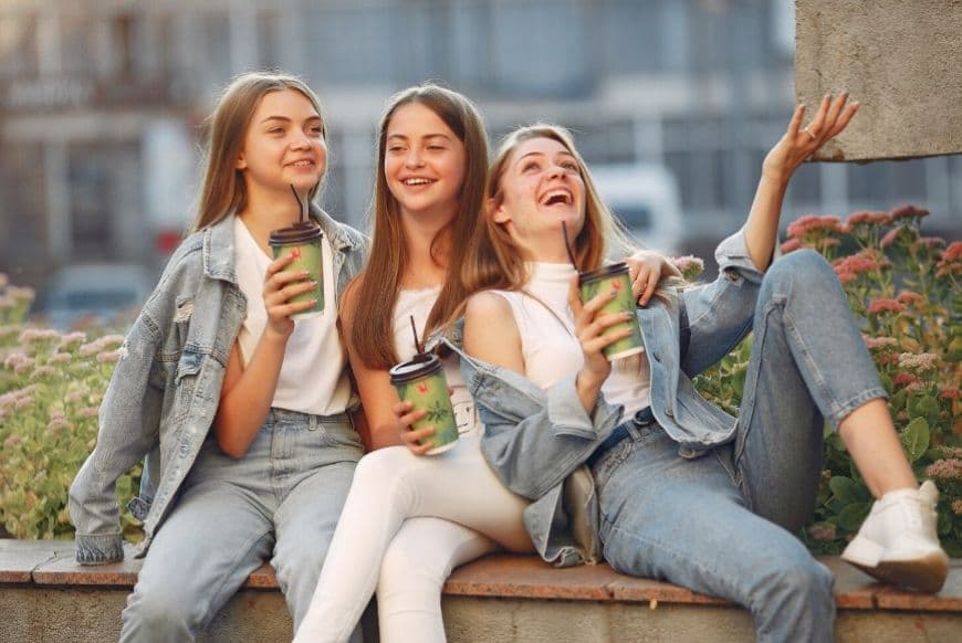 Друзі веселяться на вулиці та п'ють каву